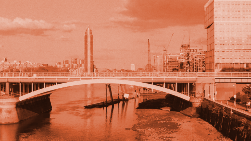 Modern white arch bridge over a river with London skyline buildings and construction cranes in the background. Hallett Financial Solutions