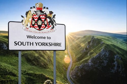 Welcome to South Yorkshire sign featuring the county coat of arms, set against rolling green hills and a winding valley road at sunrise.